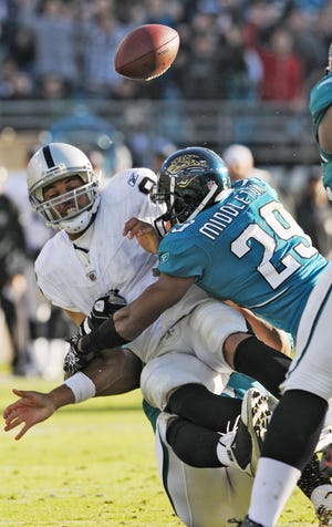 Raiders quarterback Jason Campbell is hit by the Jaguars' William Middleton (29) forcing a fumble recovered by Terrance Knighton and returned for a touchdown during the fourth quarter. The play was nullified by a personal foul against Middleton, who officials said hit Campbell in the helmet.