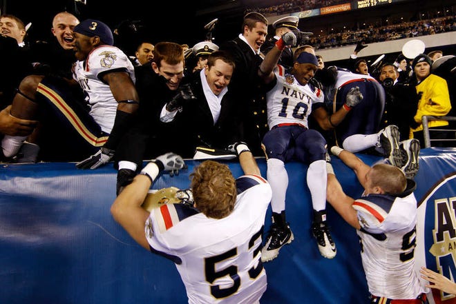 Navy players leap into the stands after their 31-17 win against Army on Saturday in Philadelphia.