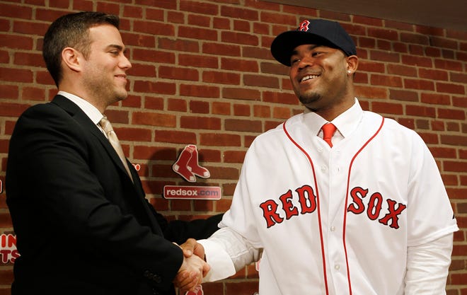 Red Sox general manager Theo Epstein, left, shakes hands with Carl Crawford at Saturday's news conference announcing Crawford's signing a $142 million, seven-year contract, at Fenway Park in Boston.