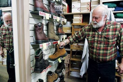 Photo by Anna Murphey/New Jersey Herald - Wayne Orr, owner of Orr’s Clothing on Main Street in Branchville, looks over the assortment of work boots he carries. Some are perfect for the outdoor enthusiast.