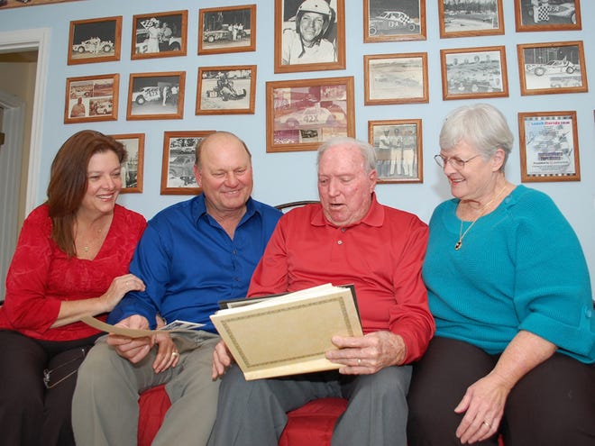 From left, Susan and Al Mincey, and Buddy and Beth Pearce view old photographs of Al and Buddy's stock car racing days. The two former stock car drivers had not seen each other in 35 years. They met at the Pearce residence after Al saw a photo of Buddy in the Gainesville Sun and contacted him.