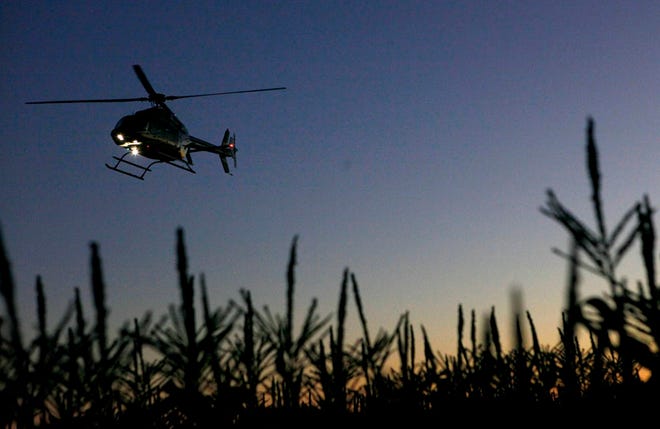 In this Dec. 8, 2010 file photo, a helicopter flies over a field of corn before dawn to push warmer air closer to the plants in an attempt to protect the corn from frost damage in Belle Glade, Fla.