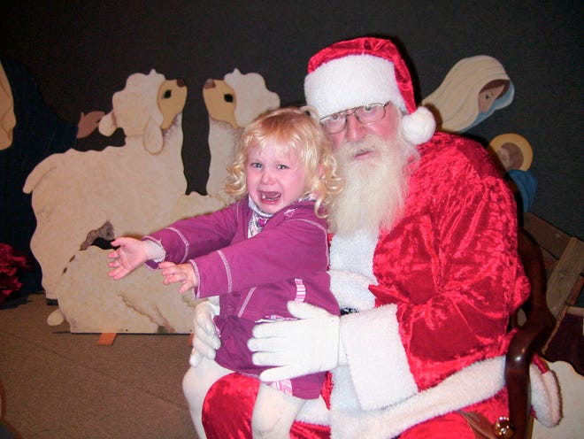 Tony Harrison's daughter, Halle Harrison, 2, sits for a photograph Dec. 14, 2006 with a man portraying Santa Claus at a preschool Christmas function in Nampa, Idaho. Halle Harrison paid her first visit to Santa at age 2, after a Christmas program in a small gym at the preschool attended by two of her three older siblings in Nampa.