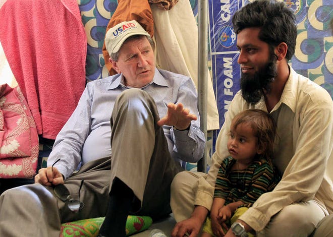 FILE - In this June 4, 2009 file photo, the top U.S. envoy to Pakistan and Afghanistan Richard Holbrooke, left, talks with a displaced man inside his tent during a visit to the Chota Lahore refugee camp, at Swabi, in northwest Pakistan. The death of Holbrooke leaves the U.S. without a tough hand whose stature, tenacity and extensive contacts allowed him to weave together once-separate diplomatic efforts in Afghanistan and Pakistan while coordinating with numerous actors there and in Washington. (AP Photo/Mohammad Sajjad, File)
