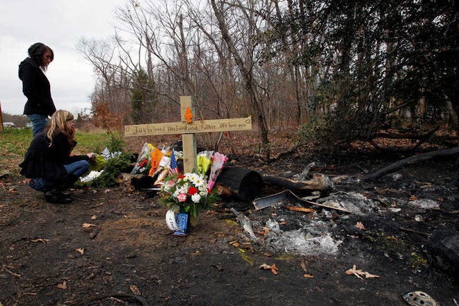 Brandie Visinski, 31, of Howell, N.J., foreground, and friend Colleen Poukish, back, 31, of Ocean Township, N.J., react at the scene of a fatal car accident Friday, Nov. 26, 2010 in Ocean Gate, N.J. A New Jersey police officer headed home after working a special anti-drunken driving detail was killed early Thursday when a drunken driver crashed into his vehicle on the Garden State Parkway, authorities said. (AP Photo/Mel Evans)