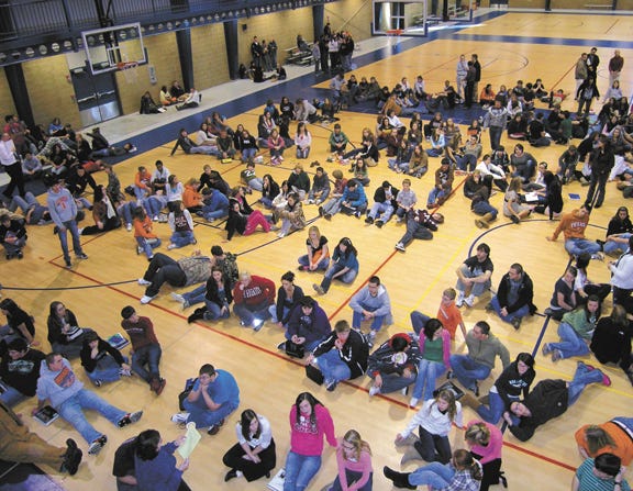 Students sat calmly in a gym at the Pontiac Recreational Center Tuesday afternoon following their evacuation from Pontiac Township High School after someone telephoned a false bomb threat into the school.
