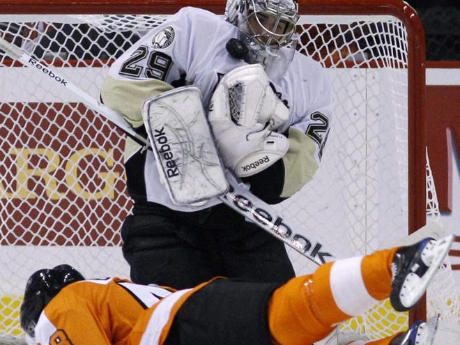 Pittsburgh Penguins goalie Marc-Andre Fleury, top, blocks a shot as Philadelphia Flyers' Danny Briere slides by in the first period Tuesday night in Philadelphia.