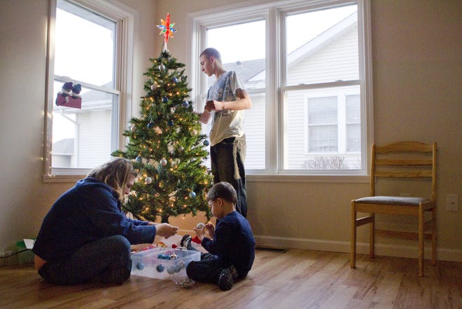 Sheila Cheek decorates her family’s Christmas tree with sons Jonah, center, and James on Friday. 
Justin L. Fowler/The State Journal-Register