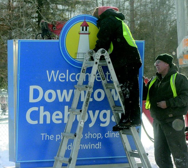 Drew Feutz (center) and Russ Pellerito of Valley City Signs work on new city of Cheboygan sign Wednesday afternoon, one of several the crew will be putting up around town this week as part of grant to the Downtown Development Authority.