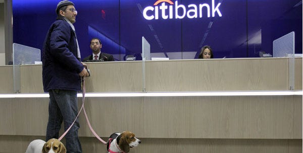 Gary Steikohl, of Manhattan, with his beagles Thelma, right, and Louise conducts a transaction with the teller at Citibank's new high-tech banking center in New York's Union Square on Thursday.