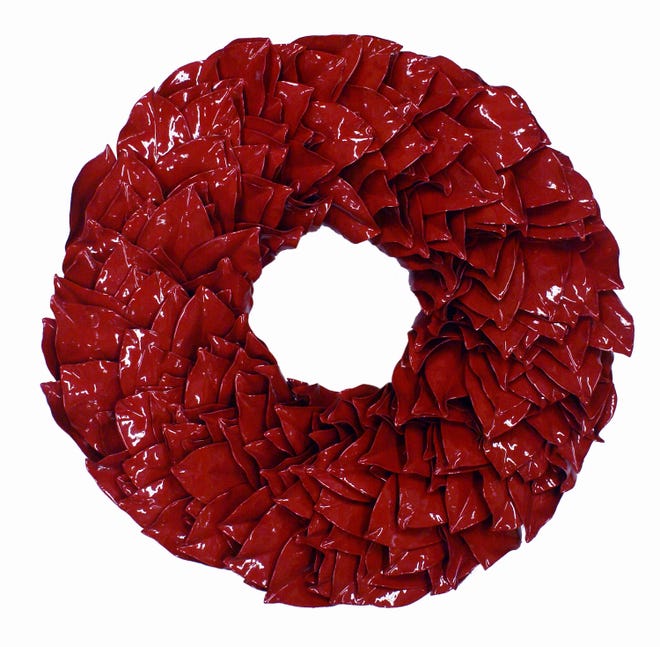 This product image courtesy of The Magnolia Company/Mary Waugh shows a wreath made of magnolia leaves and coated and sealed with holiday-red lacquer. As shiny as glass, this wreath will last indefinitely.
