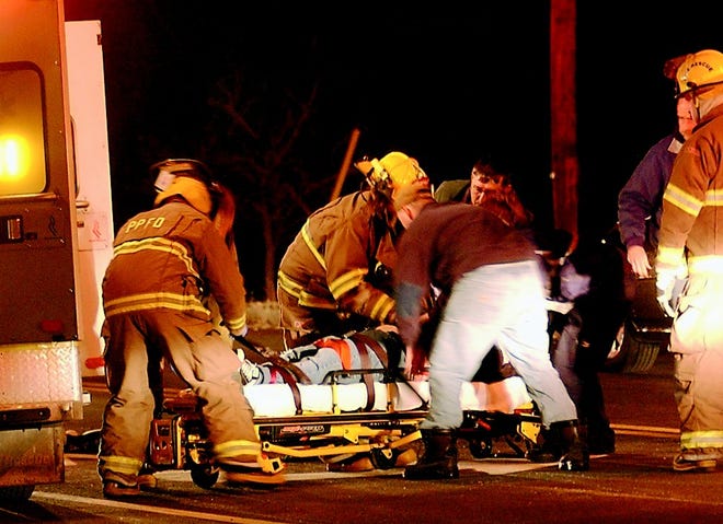 Rescue workers place an injured 15-year-old girl onto a stretcher after she was hit by a car in front of West High School Friday night.