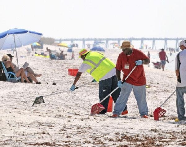 Workers remove tar balls from Pensacola Beach, Fla. The lingering economic recession, a record cold Florida winter and the effects of the Gulf oil spill stalled the tourist traffic in parts of the state.