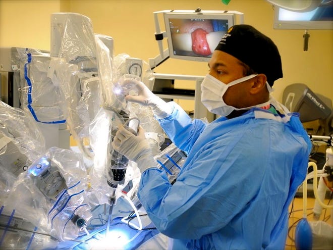 Dr. Sijo Parekattil, director and medical director of robotics at Winter Haven Hospital, makes adjustments on the da Vinci S-1 prior to a procedure at the hospital in Winter Haven on Wednesday.