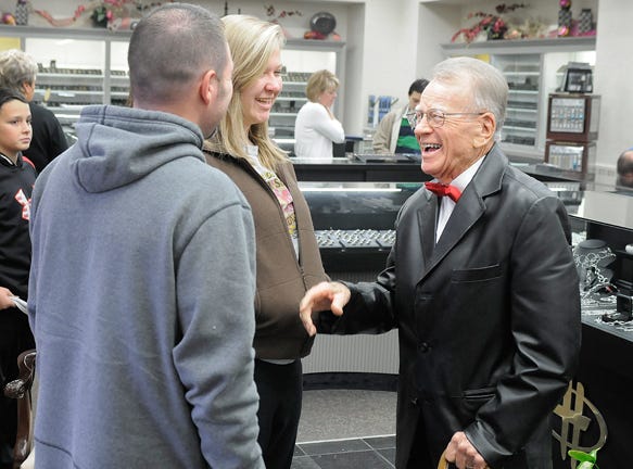 Customer greeter Harry Hartley (right) laughs with Lacey Grubbs (center) and Kolan Smith as they arrive at Hayes Jewelers to shop for jewelry Wednesday morning.