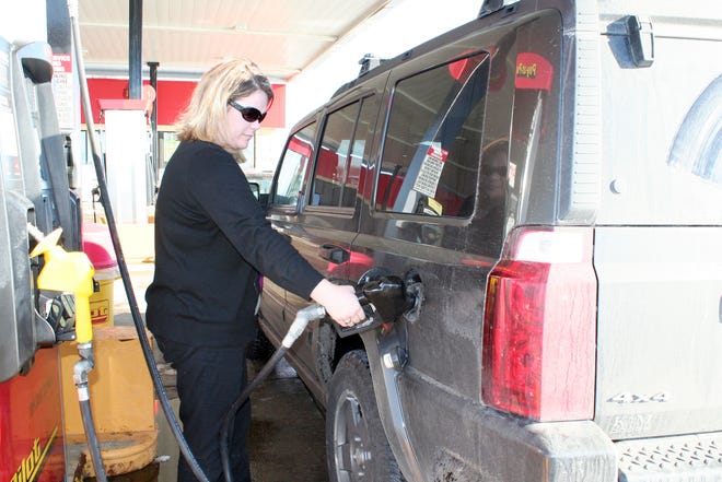 Jamie Murray from Grand Rapids pumps gas at a local station before heading east to Detroit.