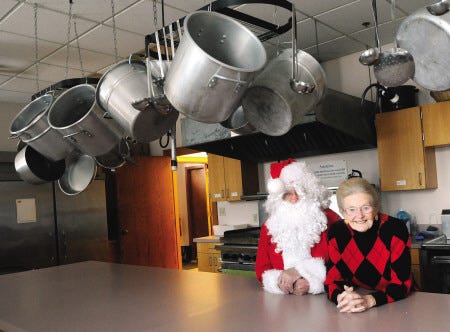 Eva Barnfeather poses with Santa Claus in the kitchen of St. Martha's Church in Kennebunk.