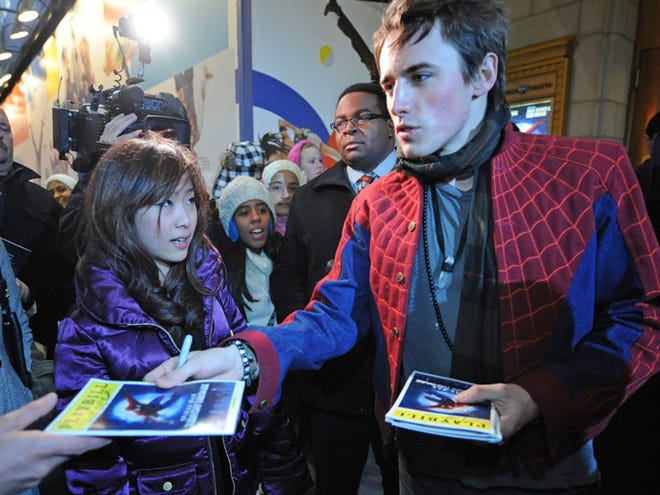 Reeve Carney who plays Spider-man in the theatrical version "Spider-Man: Turn off the Dark" autographs Playbill copies for ticket holders as Joanna Li, center, looks on outside the Foxwoods Theatre in Times Square, Wednesday, Dec . 22, 2010, in New York. The show was abruptly canceled by the state Labor Department due to safety issues following an accident that injured stunt double Christopher Tierney.