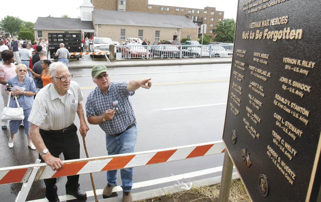 Robert Bethune, father of Robert E. Bethune, and Ron Bethune, brother of Robert E. Bethune, find his name on the plaque at the Vietnam Veterans Memorial Viaduct in Massillon.
