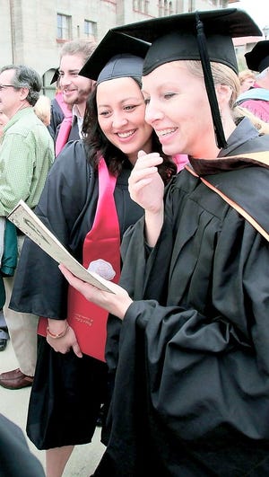 A couple of Flagler College graduates smile on Dec. 11, graduation day. By DARON DEAN, daron.dean@staugustine.com