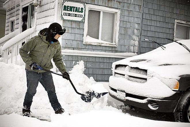 Steve Jacob of Hampton shovels the snow in front of his vehicle after strong winds made snow removal tough along H Street in Hampton Beach Monday.
