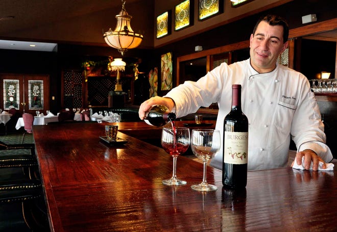 Philippe Forcioli, executive chef at Cliffbreakers Riverside Resort, pours a glass of wine inside the recently remodeled wine bar. Cliffbreakers, like many venues in the Rock River Valley, will have a range of New Year's celebration options that cater to the range of cash partygoers may have to spend.