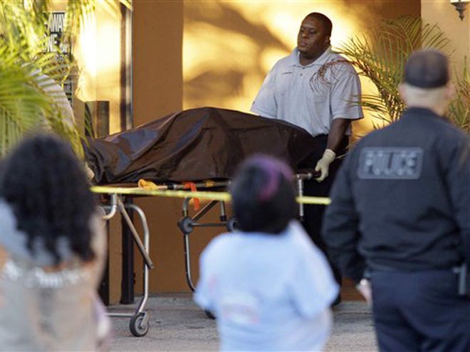 In this Monday, Dec. 27, 2010 photo, the body of one of five victims who authorities believe apparently died of carbon monoxide poisoning is removed from a motel room, in Hialeah, Fla. A car used by the group of teenagers was found running in a closed garage underneath the room.