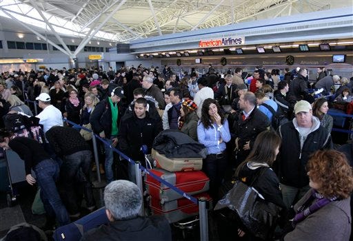 Air travelers wait in line to find out the status of their flights at John F. Kennedy International Airport in New York, Monday, Dec. 27, 2010. (AP Photo/Seth Wenig)