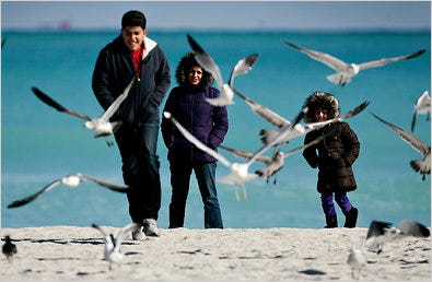 Sepehr Ardebimian, with his mother, Sholeh, and sister, Parastou, who were on a visit to Miami Beach from Georgia, endure the uncharacteristically brisk winds and temperatures.