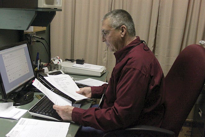Ionia Theatre Director Gary Ferguson looks through papers displaying sales from this year.