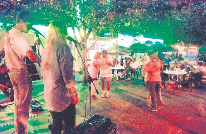 Acoustic musicians perform on a Friday night outside the Main Street Depot 
in downtown Sarasota in 1998. After the city passed restrictions on outdoor 
music, the owner of the business switched from rock 'n' roll to duos and 
trios with no drums. However, the Lemon Avenue venue closed that July. 
HERALD-TRIBUNE ARCHIVE / 1998