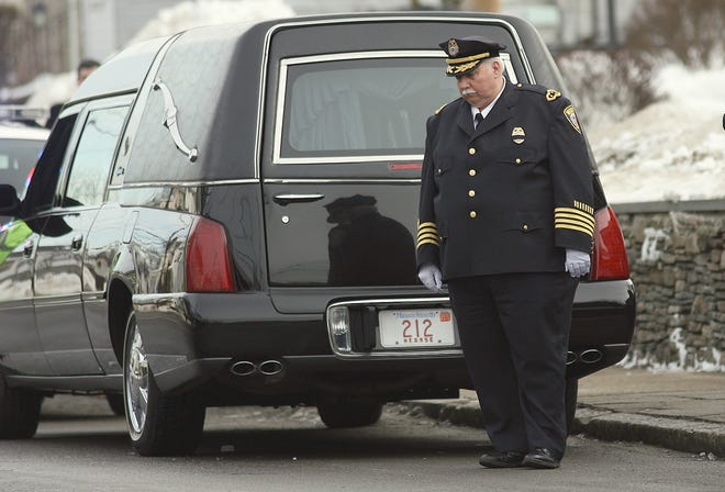 Woburn Police Chief Phillip Mahoney stands by the hearse while waiting for the casket of Officer Jack Maguire to be brought out of the funeral home.