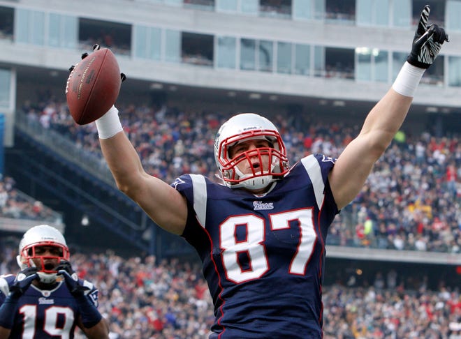 Patriots tight end Rob Gronkowski celebrates his touchdown reception in front of wide receiver Brandon Tate in the first quarter of the Pats' victory over Miami on Sunday.