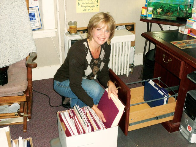 Jacqui Biernat, a life coach and founder of Light-r-u,LLC, gets organized at her Canandaigua office.