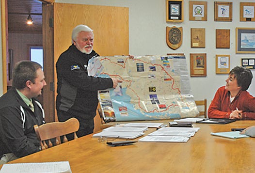 President Bill Bradfield of MichCanSka details the 2011 route for his group of avid snowmobile riders as Sault Events Coordinator Nathan Gregorich and Executive Director Leisa Mansfield look on. MichCanSka raised over $100,000 last year for diabetes research as the group piloted snowmobiles from Sault Ste. Marie to Tok, Alaska in its inaugural run.