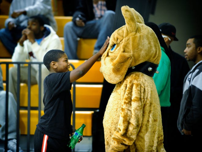 Johnny Grissom, 10, greets the Butler High School Bulldog mascot with a pat on the nose between the boys' and girls' basketball games pitting Butler against Josey High.