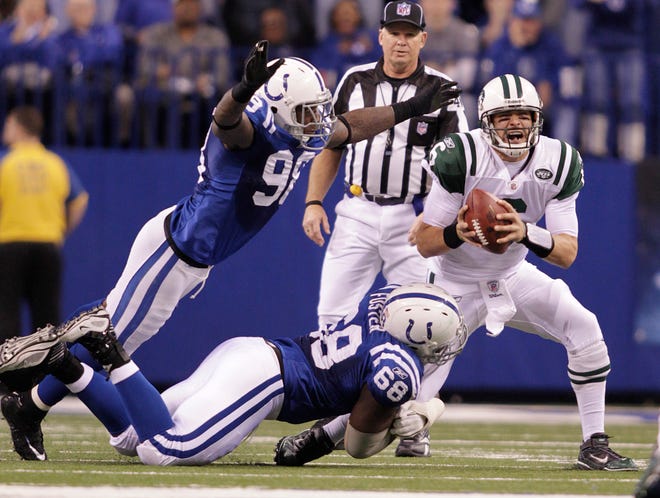 New York quarterback Mark Sanchez (right) is sacked by Indianapolis' Eric Foster (bottom) and Robert Mathis. Nick Folk kicked a 32-yard field goal as time expired to allow the Jets to advance.