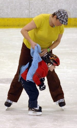 Jennifer McParland uses a jacket to hold up and teach her 3-year-old, Seamus McParland-Daab, how to skate Saturday during the clinic at the Jacksonville Ice & Sportsplex.