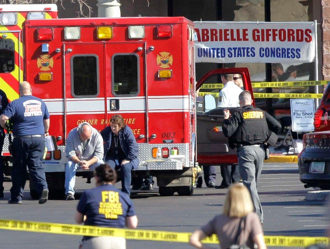 Emergency personnel work at the scene where Rep. Gabrielle Giffords, D-Ariz., and others were shot outside a Safeway grocery store Saturday, Jan. 8, 2011, in Tucson, Ariz.