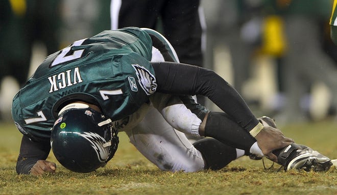 Eagles quarterback Michael Vick holds his ankle during the second half.