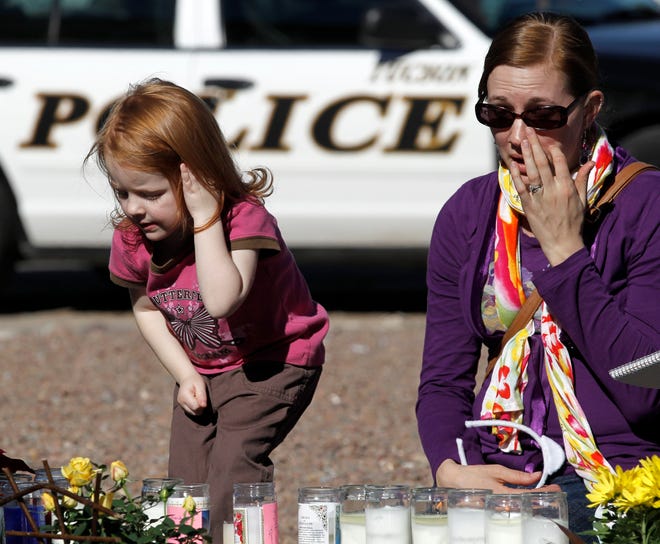 Melissa Callahan, right, and her daughter Jillian Stanley, 3, pay their respects outside U.S. Rep. Gabrielle Giffords' office at a make-shift memorial in Tucson, Ariz., Sunday, Jan. 9. U.S. Rep. Gabrielle Giffords, D-Ariz., was shot in the head Saturday during an event at a local supermarket.