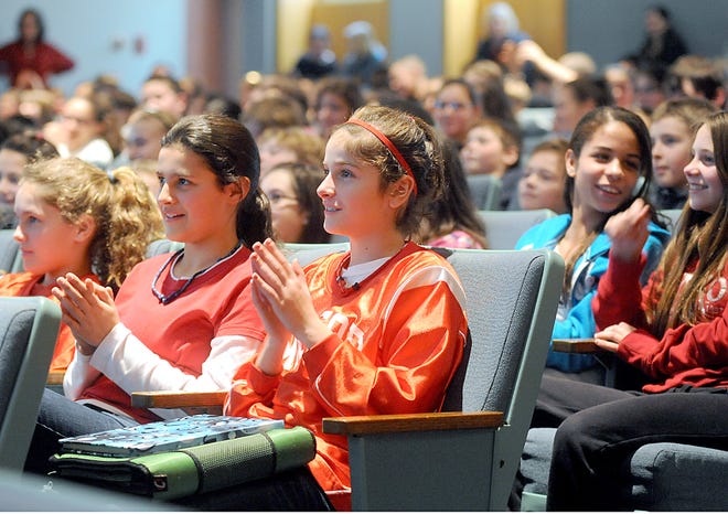 Stacy Middle School sixth-graders Sydney Morrison, left, and Emma Liskov and their classmates watch entertainer Tezz Yancey perform during The Digits Project, a program that teaches students about careers in math and science, in a presentation at the school yesterday.