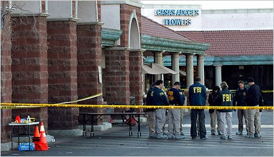 Crime scene investigators paused during a moment of silence on Monday at the site of Saturday’s shooting in Tucson.