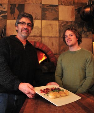 Mark Schrock, owner of Salt of The Earth, and Salt of The Earth General Manager Andrew Briggs pose a seared scallop dish which is available at Salt of The Earth.