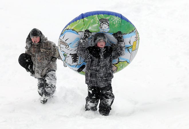 Makay Morrison, 11, left, and Zack Shinnick, 7, spent their day off from school sledding and snowboarding, Wednesday in Millis.