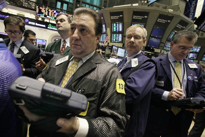 Traders gather at the post that handles ITT Corp. on the floor of the New York Stock Exchange Wednesday, Jan. 12. The market applauded the plan: ITT shares climbed $8.72, or 16.5 percent, to close at $61.50, having risen to a 52-week high of $64 earlier in the day.