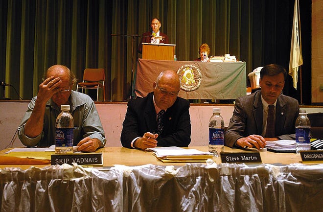 Rehoboth selectmen, from left, Skip Vadnanis, Steve Martin and Christopher Morra listen during the fourth installment of Rehoboth’s town meeting Monday at Dighton Rehoboth High School. In back are Bill Cute, moderator, and Town Clerk Kathy Conti.