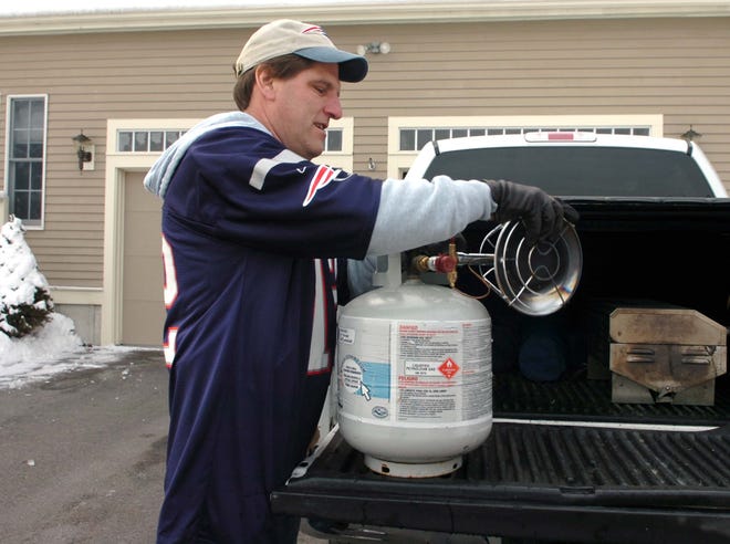 Timothy J. Holick loads a heater into the back of his pickup truck.