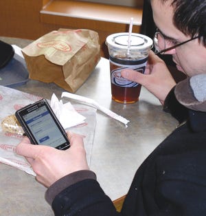 Chris Malvaso of Park Avenue in Rochester checks his Facebook account on his cell phone at Tim Hortons in Canandaigua.