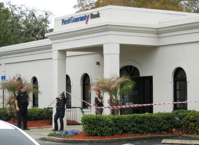 Jacksonville Sheriff's Office investigators work outside of the First Guaranty Bank at 1234 King Street where a robber handed a teller a note demanding cash.